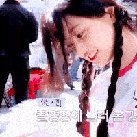 a woman with braids is smiling and looking at something