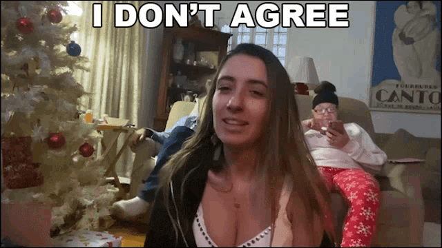 a woman sitting in front of a christmas tree with the words " i don 't agree " above her