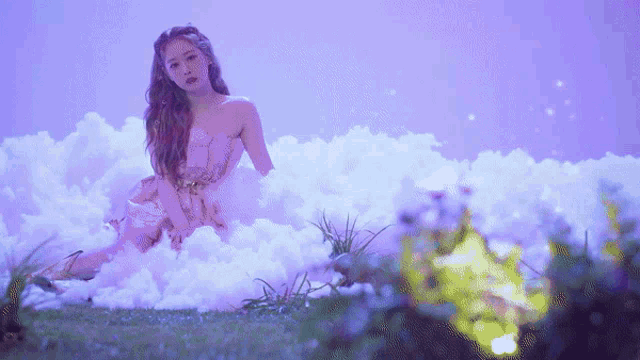 a woman in a dress is sitting on a cloud in the grass .