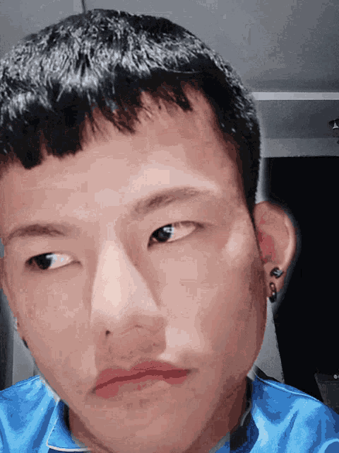 a close up of a person 's face with a blue shirt