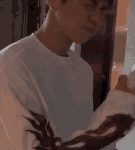 a man in a white shirt is standing in a room and looking at the camera .