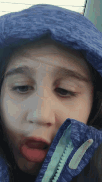 a girl wearing a blue jacket with a zipper on it