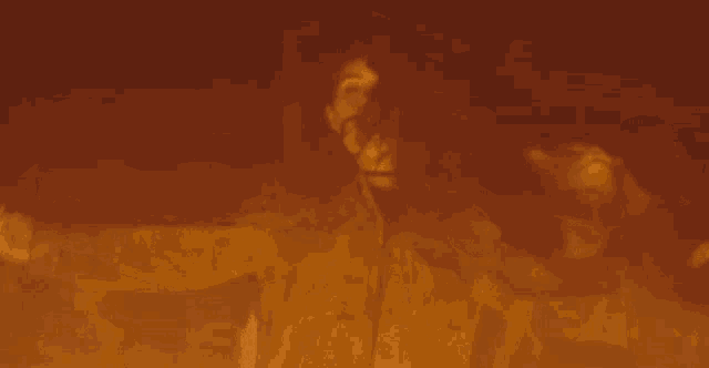 a woman is standing in front of a fire and screaming .
