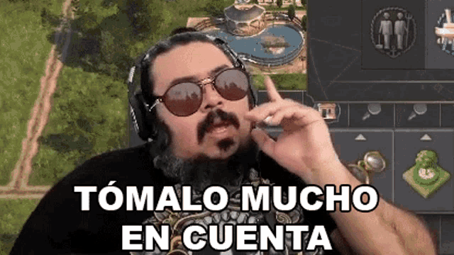 a man with a beard and sunglasses is wearing headphones and making a face .