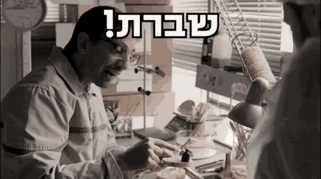 a man sitting at a desk with a sign above him that says ' sbara '
