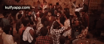a man with a beard is standing in a crowd of people and talking to another man .