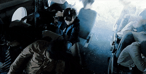 a group of people are sitting in a dark room with smoke coming out of the window