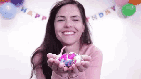 a woman is holding a bunch of confetti in her hands .