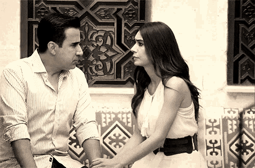 a man and a woman are holding hands and looking at each other in a black and white photo