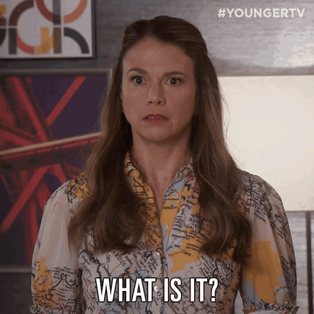 a woman wearing a shirt with a map on it says " what is it "