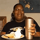 a woman is sitting at a table with a plate of food and a glass of water .
