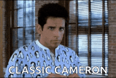 a man in a blue shirt is standing in front of a window with the words classic cameron written on it .