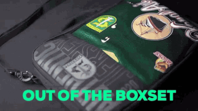 a green and black bag with the words out of the boxset
