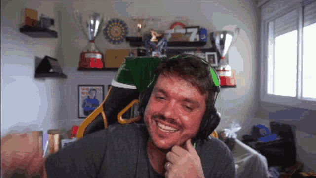 a man wearing headphones is smiling in front of trophies and a sign that says 7 on it
