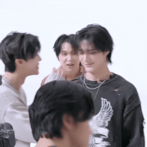 a group of young men are standing next to each other in a room .