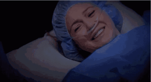 a woman wearing a surgical gown is laying in a hospital bed .