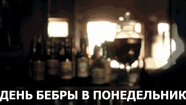 a blurry picture of bottles and a glass of wine with the words " день бебры в понедельник " written below it