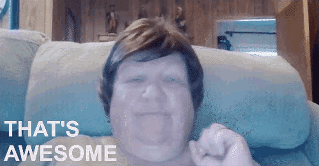 a man sitting on a couch with the words that 's awesome on the screen