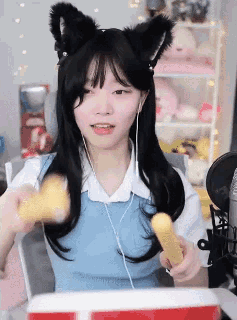 a girl wearing cat ears and headphones is holding a stick