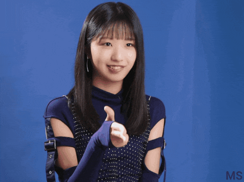 a girl giving a thumbs up in front of a blue wall that says ms on it