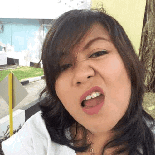 a woman is making a funny face with her tongue out while taking a selfie .