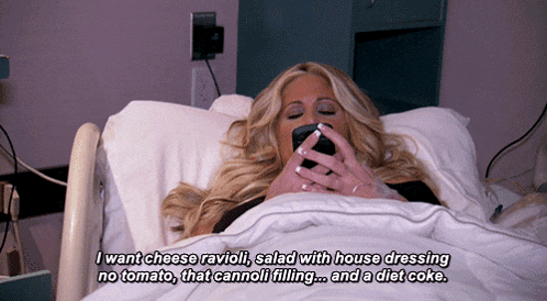 a woman is laying in a hospital bed with a cell phone in her hand