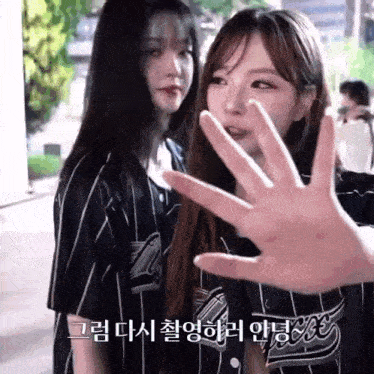 two girls are standing next to each other and one of them is wearing a jersey that says ' coca cola ' on it .