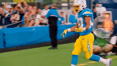 a football player in a blue and yellow uniform with the number 30 on his helmet