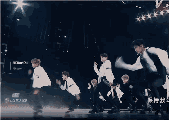 a group of young men are dancing on a stage with a lg logo in the background