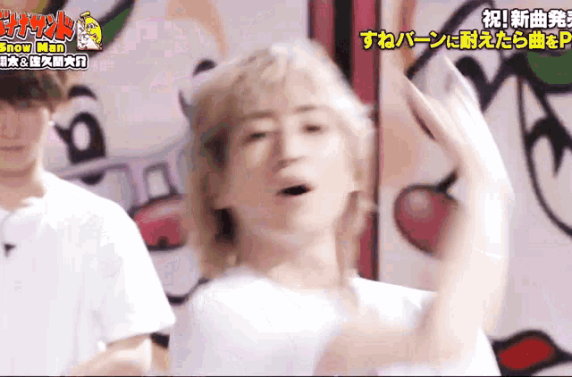 a man in a white shirt is dancing in front of a sign that says ' snow man ' on it
