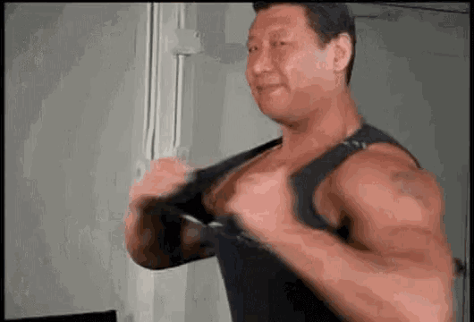 a man with a lot of muscles is wearing a tank top .