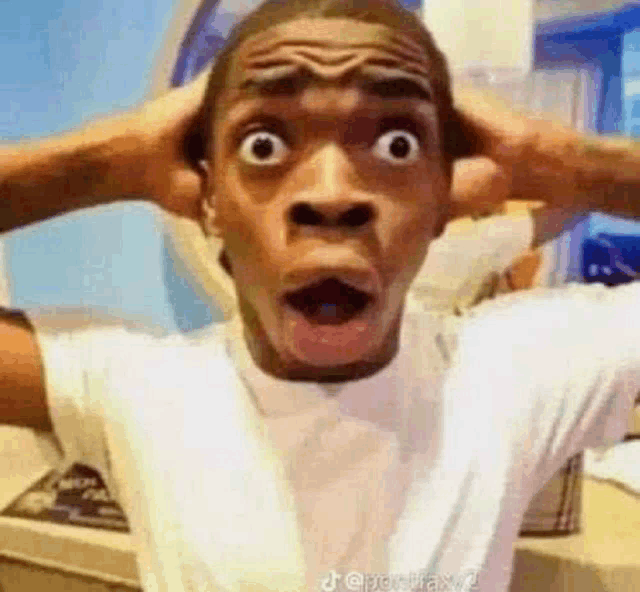 a man with his hands on his head is making a funny face .