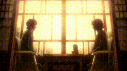 two people are sitting at a table in front of a window talking .