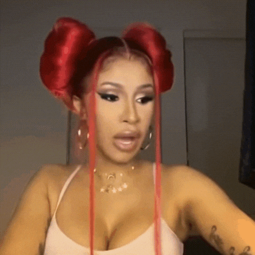 a woman with red hair is wearing a white tank top and earrings .