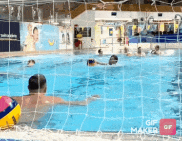 a group of people are playing water polo in a swimming pool .