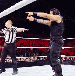 a referee and a wrestler in a ring with a crowd behind them