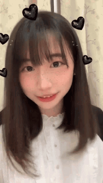 a young girl with hearts on her hair and a white shirt