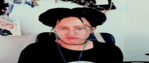 a woman with dreadlocks and a choker is sitting in a chair