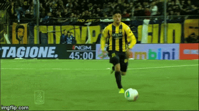 a soccer player is kicking a ball in front of a sign that says immagine.com