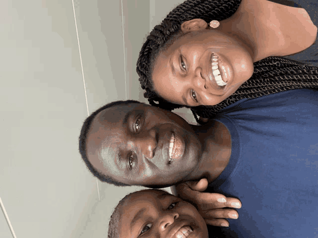 a man and woman are posing for a picture with a little boy