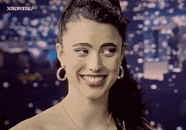 a woman wearing hoop earrings and a necklace smiles with xtecystali written on the bottom right