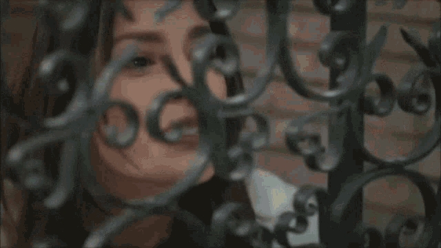 a man behind a wrought iron fence with a swirl design