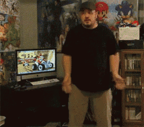 a man is dancing in front of a computer screen that says crash bandicoot on it