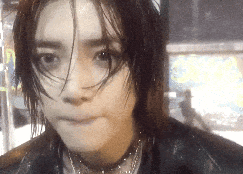 a close up of a person 's face with a choker and wet hair