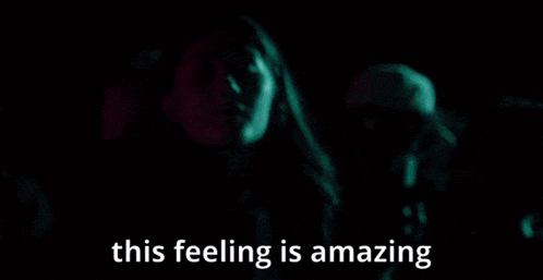 a woman is dancing in a dark room with the words " this feeling is amazing " below her