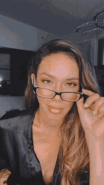 a woman wearing glasses looks at the camera