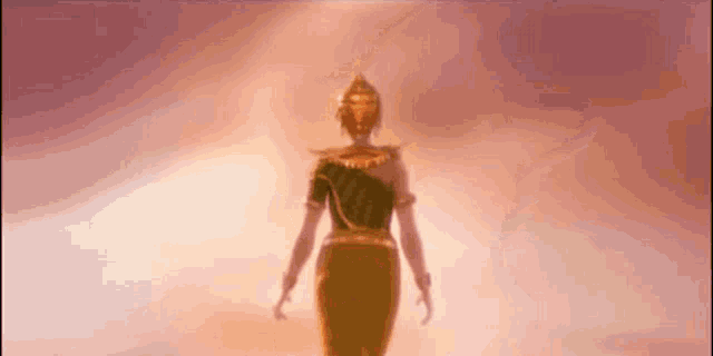 a silhouette of a woman in a green and gold dress