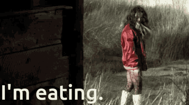 a girl in a red jacket stands in a field with the words i 'm eating below her