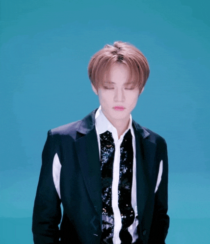 a young man in a suit and tie is looking down