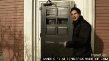 a man in a black jacket is standing in front of a door that says make gifs at benderconverter.com